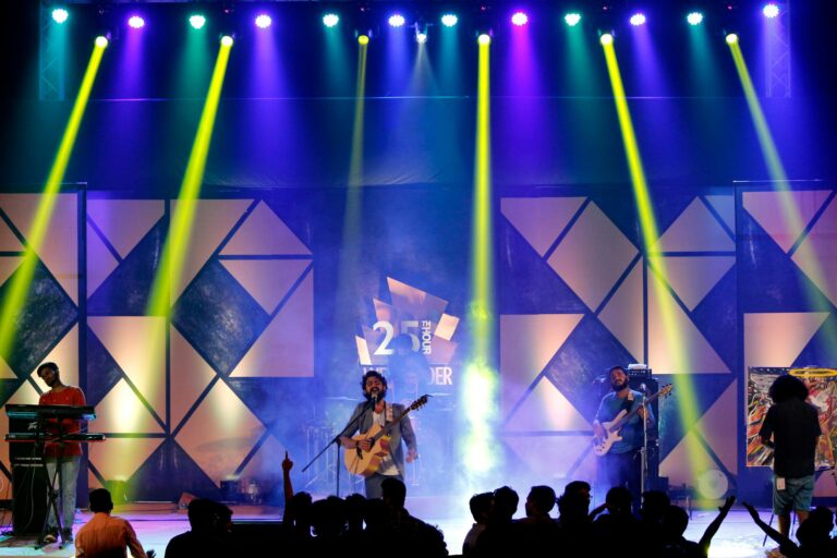 Energetic live band performance on stage with dynamic lighting at night.